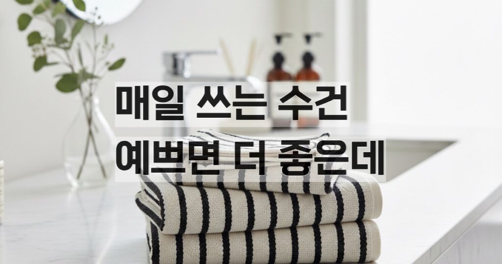 욕실 세면대 위에 베이지 블랙 스트라이프 패턴 수건이 3장 올려져있다